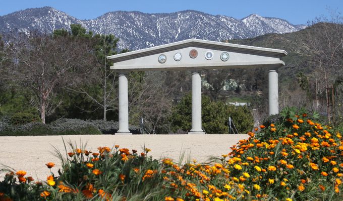 The monument in Flag Hill Park in Yucaipa with the San Bernardino Mountains